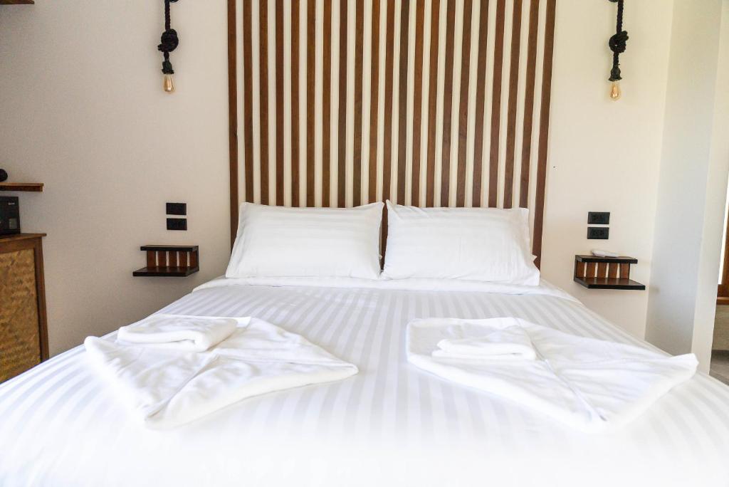 a white bed with two white towels on it at Mae Ya Resort in Ko Tao