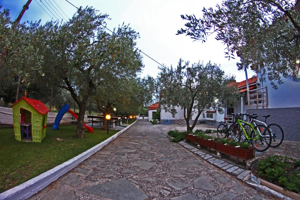 una calle con bicicletas estacionadas en un parque con árboles en Dimos Bungalows en PalaiónTsiflíkion