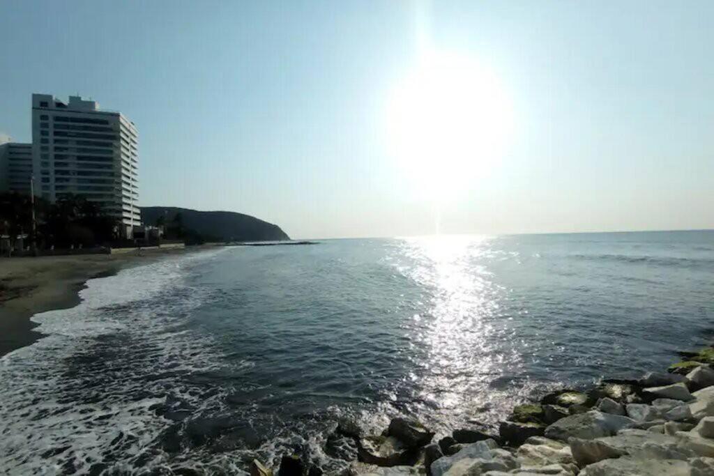 einen Strand mit Sonne auf dem Wasser in der Unterkunft Apartamento con vista al mar Santa Marta Colombia in Playa Bello Horizonte