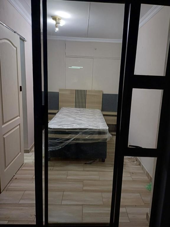 a view of a room with a bed through a door at Single room for 1 in Vereeniging