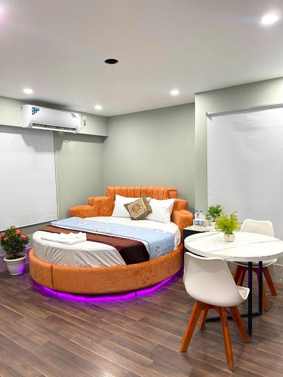 a bedroom with a large bed and two tables at Family Inn - Airport Hotel in Dhaka