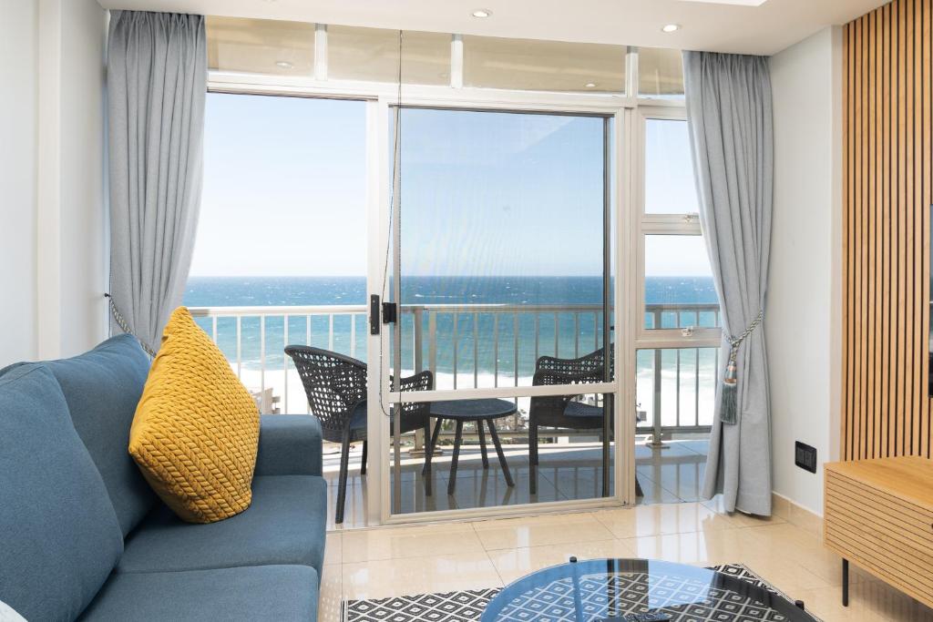 a living room with a blue couch and a view of the ocean at Coastal View @ 1304 La Ballito in Ballito