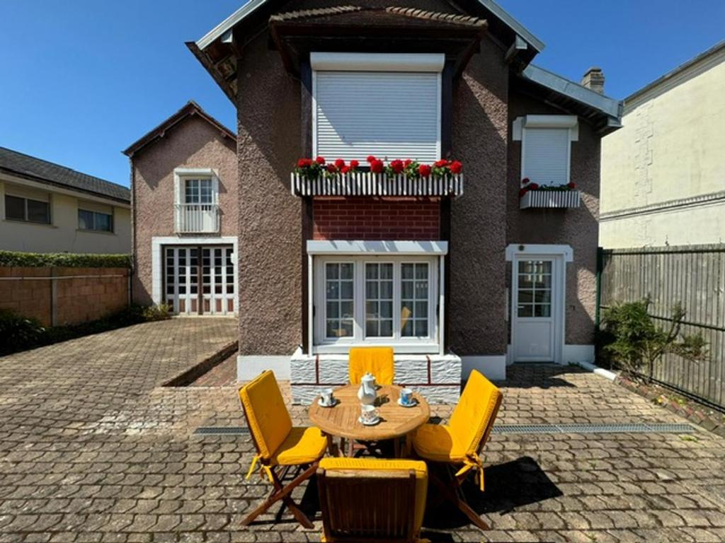 a patio with a table and chairs in front of a house at Charmant T2 avec Terrasse et Parking Privé, Tout Confort, Proche Trouville - FR-1-712-88 in Touques