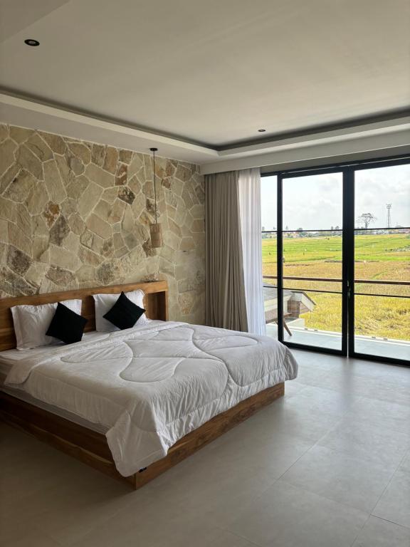 Un dormitorio con una cama grande y una ventana grande. en Paddy's House Seseh, en Canggu