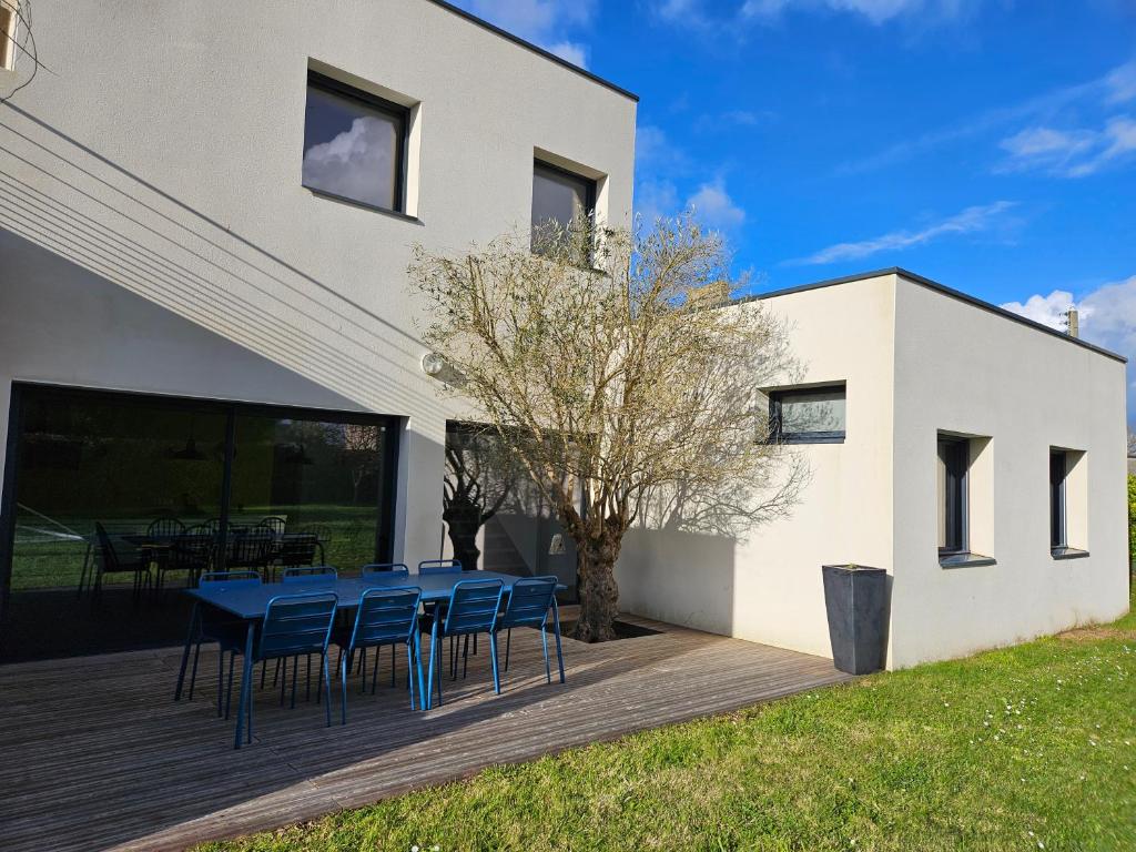 une table et des chaises sur une terrasse à côté d'un bâtiment dans l'établissement Maison d'architecte 9p - 400m de la mer & du bourg, à Santec