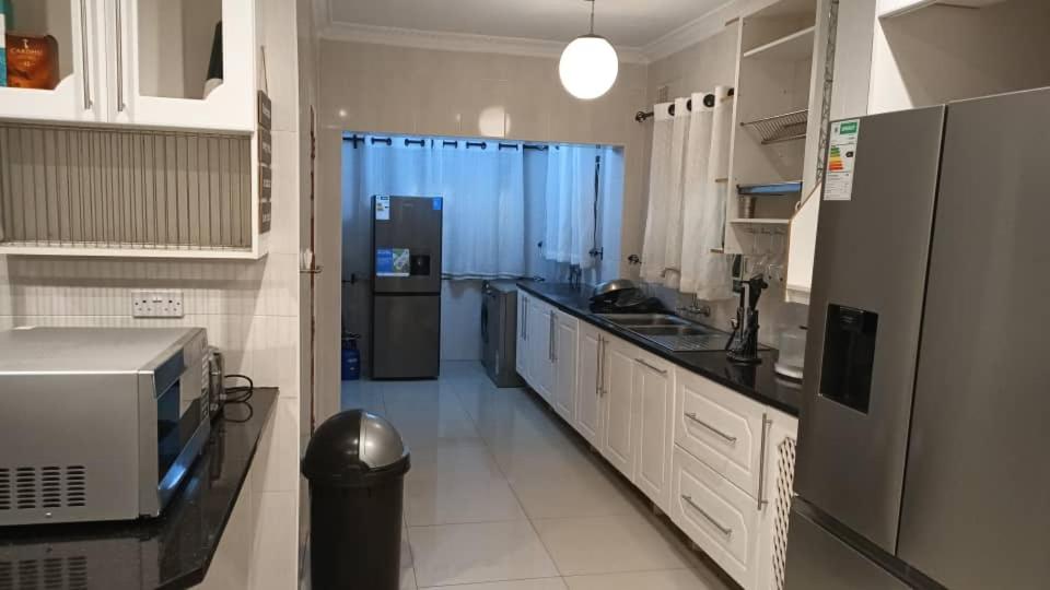 a kitchen with a refrigerator and a counter top at Elegant BnB in Bulawayo
