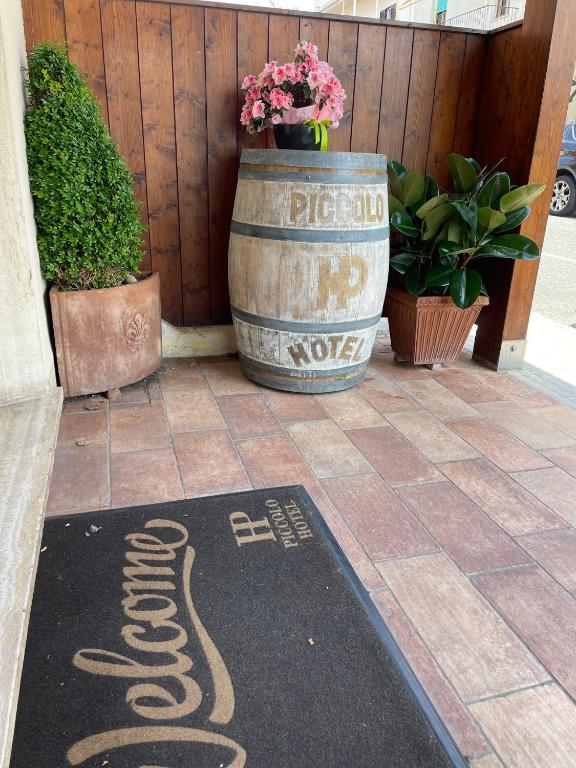 a welcome mat on the ground in front of a barrel at Piccolo Hotel in Rosignano Solvay