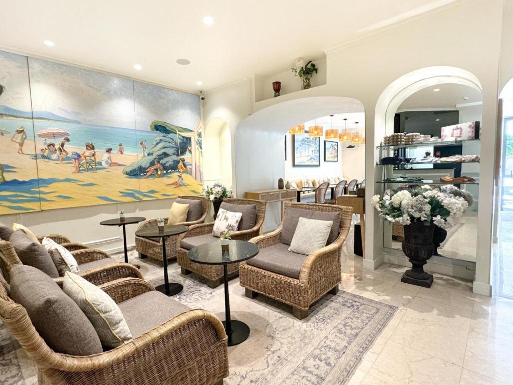 a lobby with chairs and tables and a painting at Hôtel de Provence in Cannes
