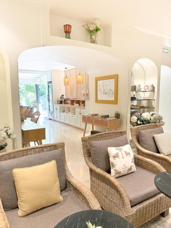 a living room with wicker chairs and a table at Hôtel de Provence in Cannes