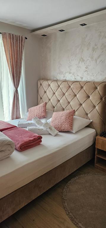 ein Schlafzimmer mit einem großen Bett mit rosa Kissen darauf in der Unterkunft Green Hill Isidorovic Divcibare in Divčibare