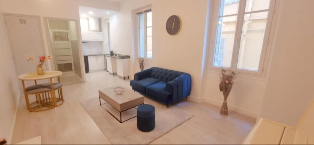 un salon avec un canapé bleu et une table dans l'établissement Appartement cosy moderne calme hyper centre gare sncf, à Nice