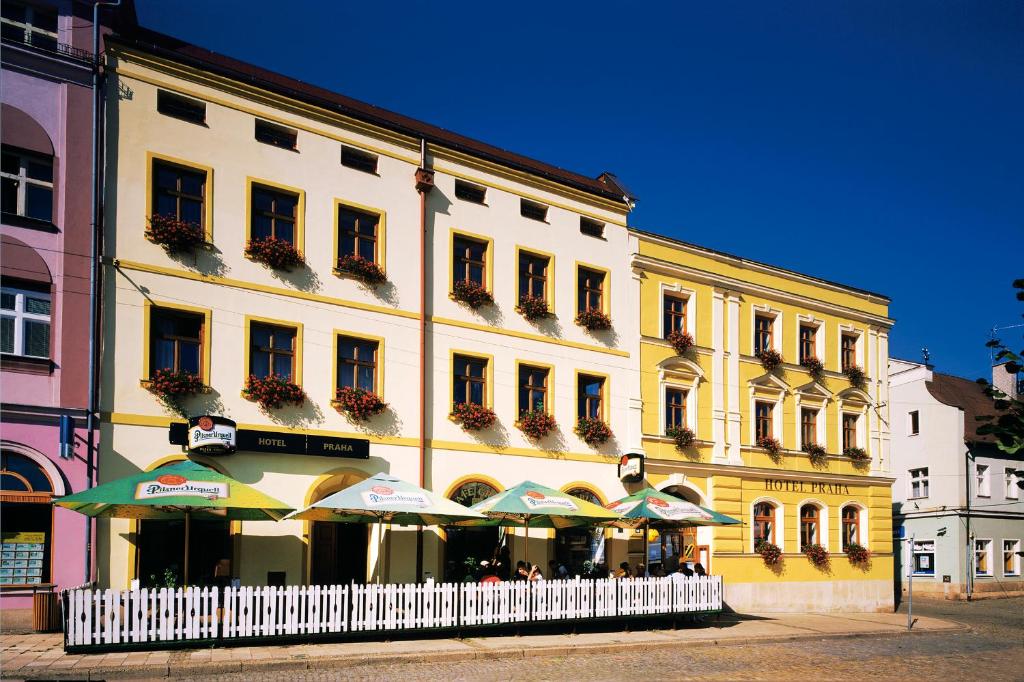 een groot gebouw met parasols ervoor bij Hotel Praha in Broumov