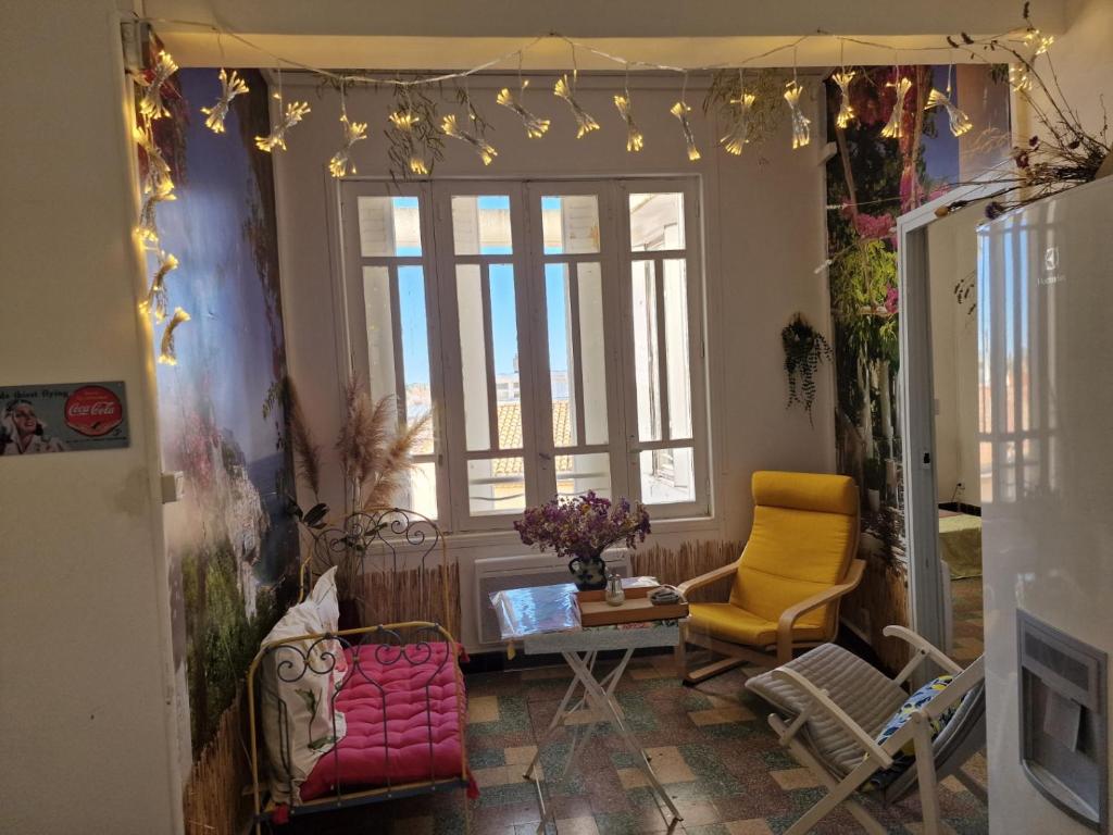 - un salon avec des chaises et des lumières sur le mur dans l'établissement La Citadelle Médiévale - Appartement, à Béziers