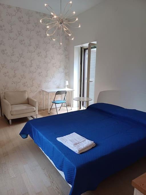 a bedroom with a blue bed and a chair and a chandelier at RMG Home in Fisciano