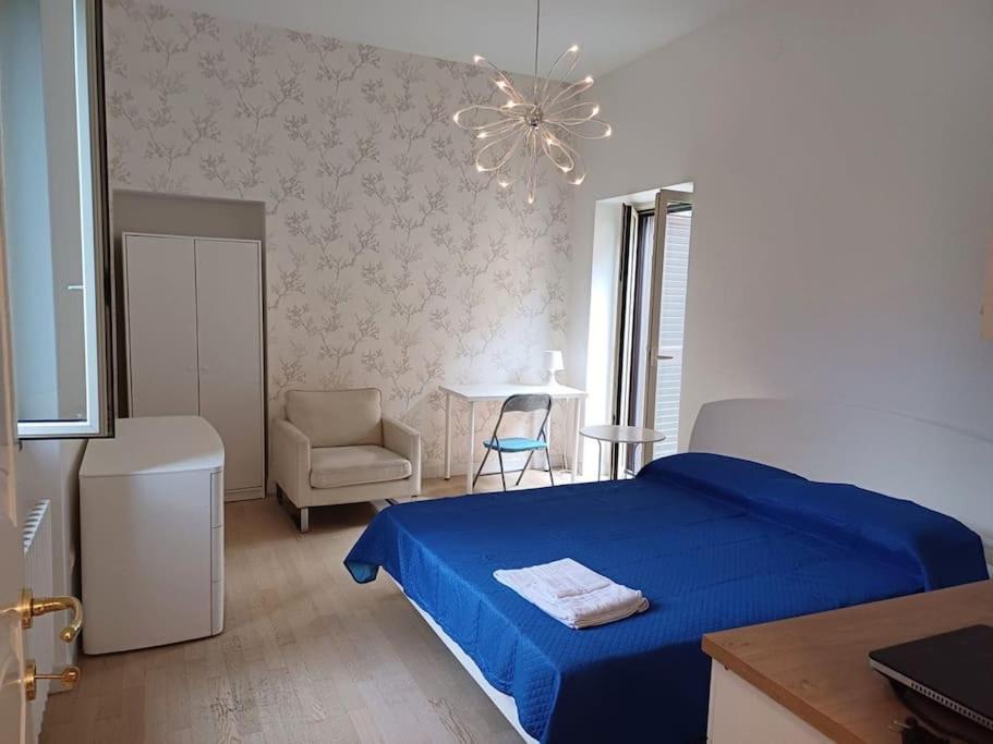 ein Schlafzimmer mit einem blauen Bett und einem Stuhl in der Unterkunft RMG Home in Fisciano