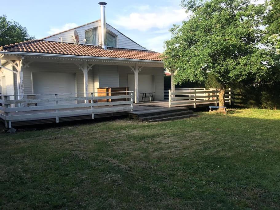 une maison blanche avec une terrasse couverte et une cour dans l'établissement Villa 180m2 proche Lac Hourtin, à Hourtin