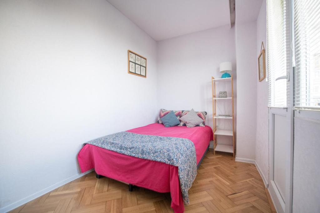 Un dormitorio con una cama con una manta rosa. en 70 mbps Work-friendly and Creative, en Tiflis