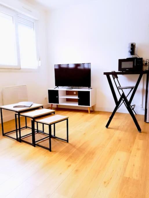 - un salon avec deux tables et une télévision à écran plat dans l'établissement Le Studio De Gustave, à Lens