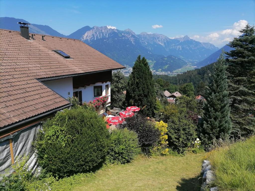 a house with umbrellas on a hill with mountains at Landhaus Berthold in Bürserberg