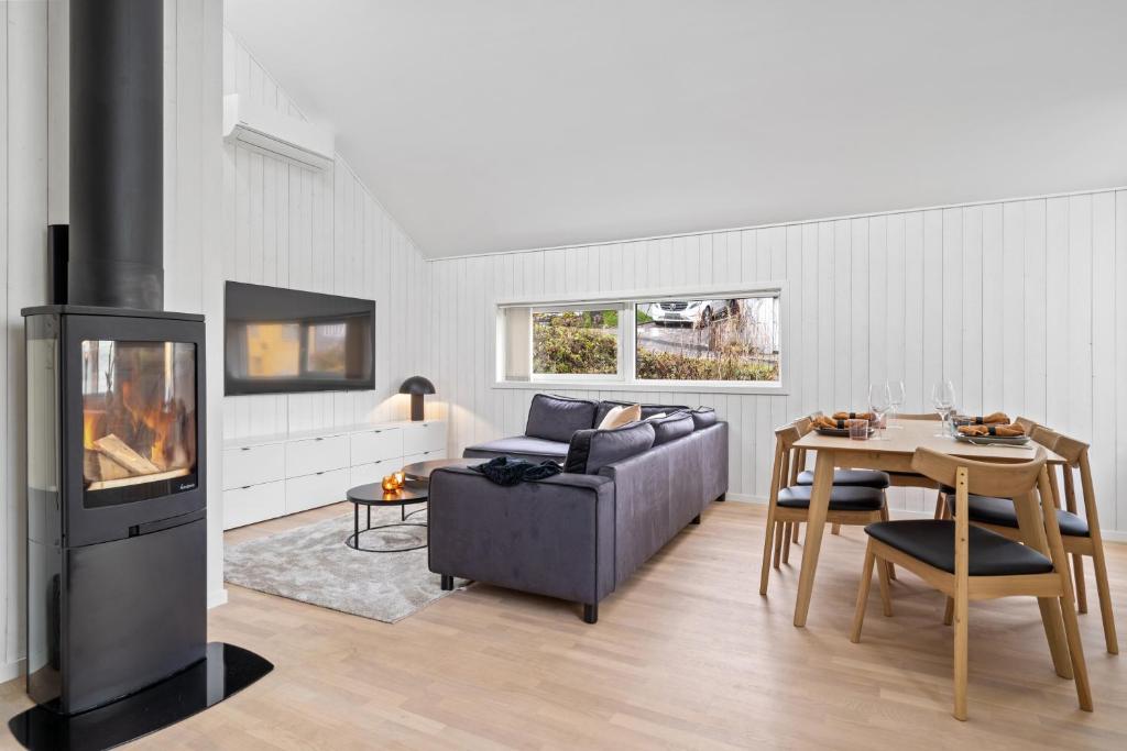 a living room with a couch and a table and a fireplace at Cozy house house in city centre in Tromsø
