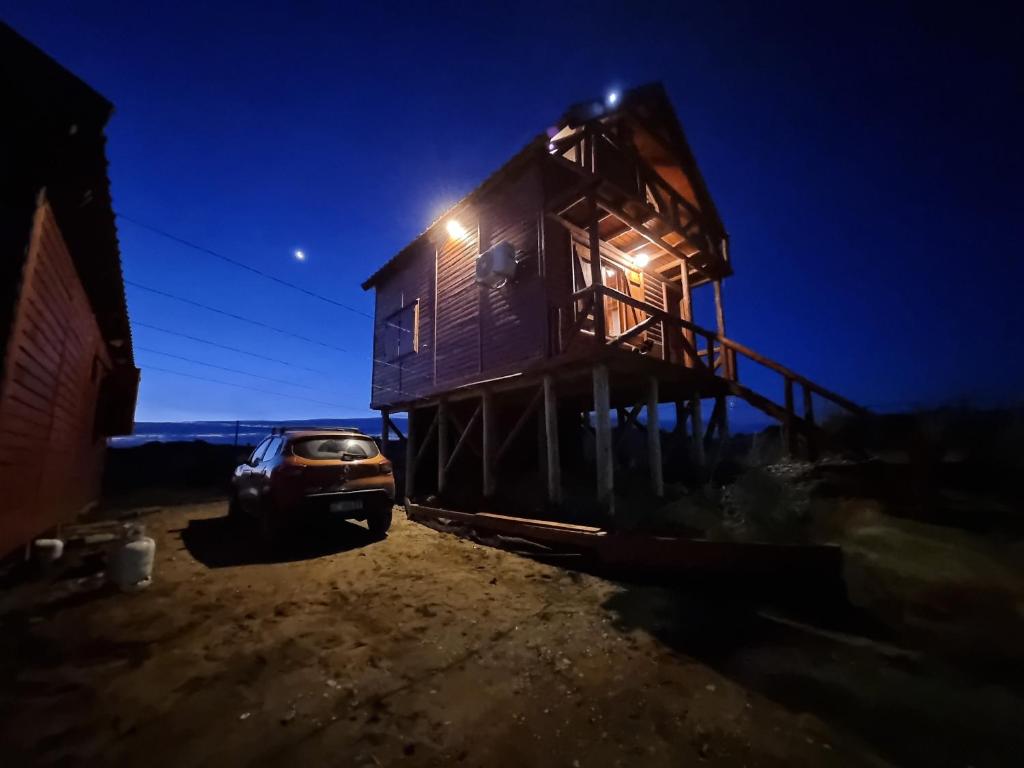 una casa con un coche aparcado delante de ella por la noche en Los olivillos, en Balneario Pehuén-Có