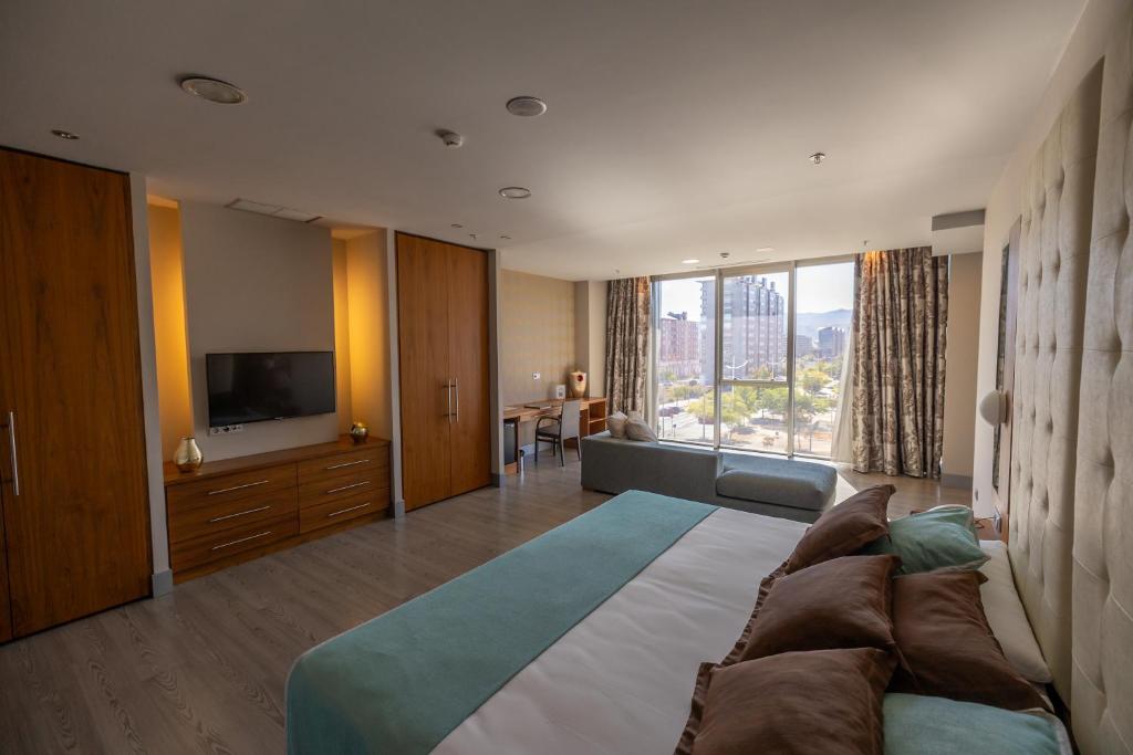 Un dormitorio grande con una cama grande y un televisor. en Hotel Ciudad de Ponferrada, Ascend Hotel Collection, en Ponferrada