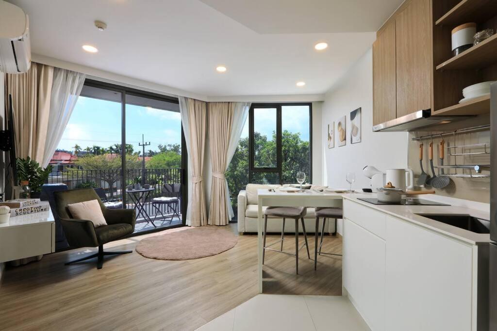 a kitchen and living room with a view of a patio at Sky Park condo 1 bedroom in Laguna Phuket