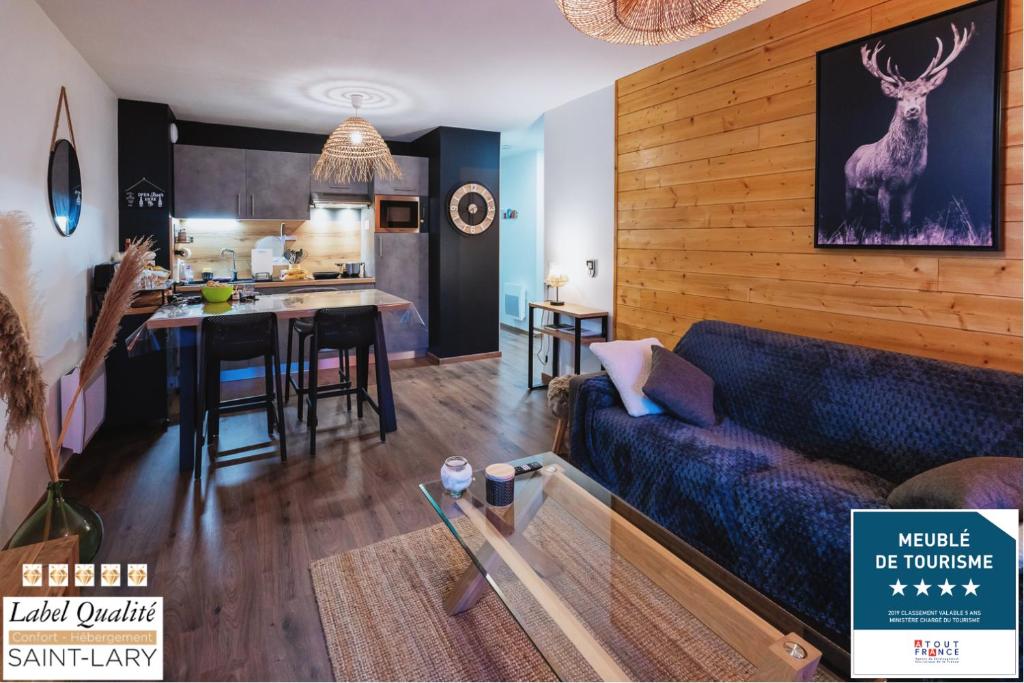 un salon avec un canapé bleu et une cuisine dans l'établissement Magnifique appt NEUF 6 pers - vue montagne St Lary - curistes ok, à Vielle-Aure