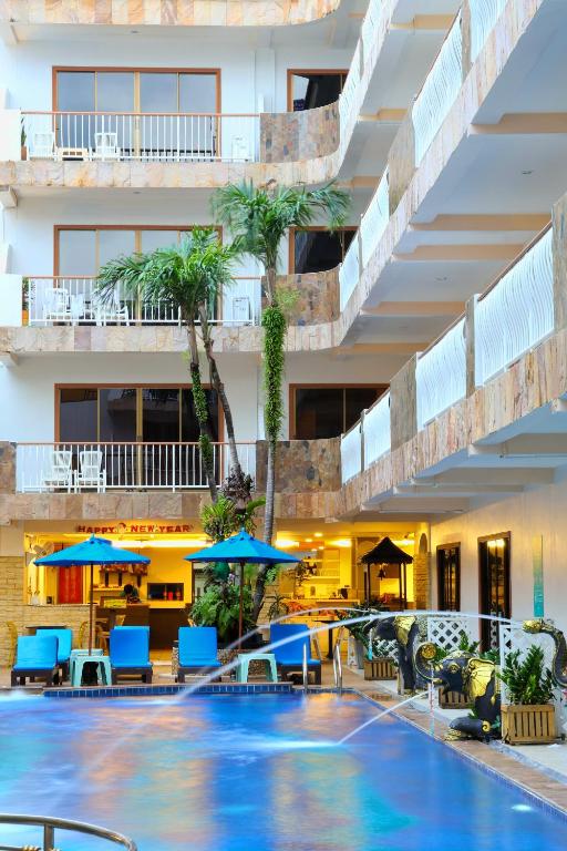 a hotel with a swimming pool with chairs and umbrellas at Baan Boa Resort in Patong Beach