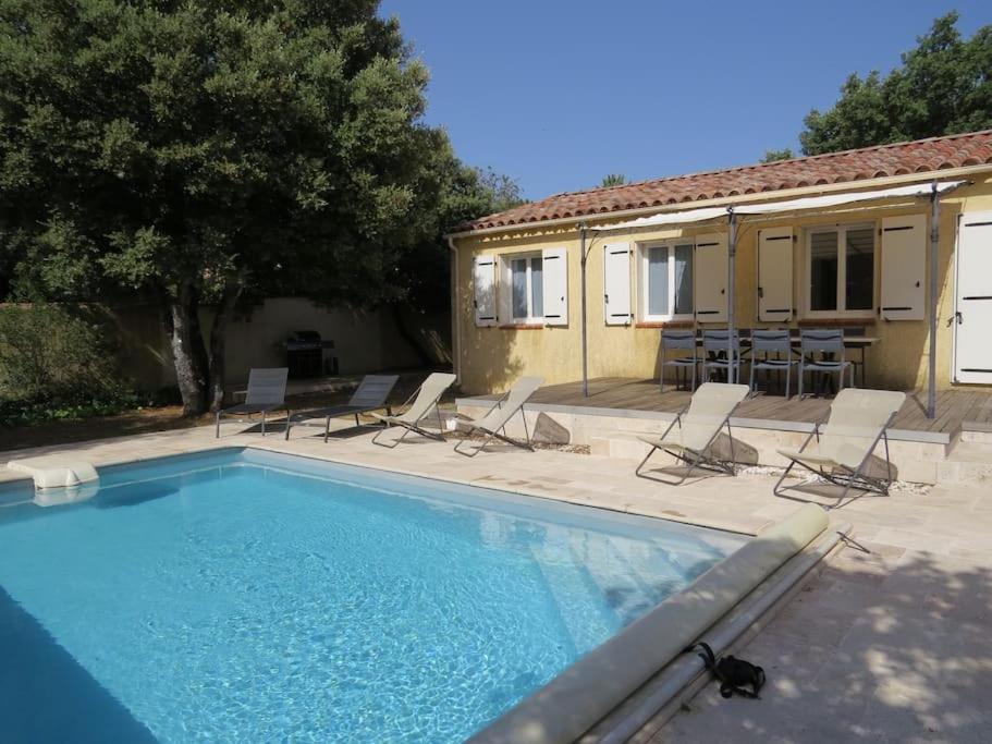une piscine avec des chaises et une maison dans l'établissement Maison avec piscine dans le haut var, à Régusse