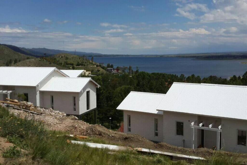a row of white houses on top of a hill at Dique Los Molinos Exclusiva casa vista al lago in Cordoba