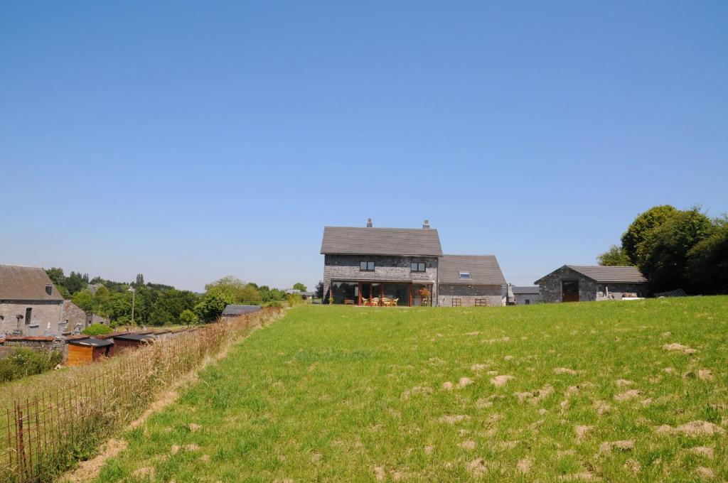 een huis op een heuvel met een veld bij A côté de l'Epicerie in Bonsin