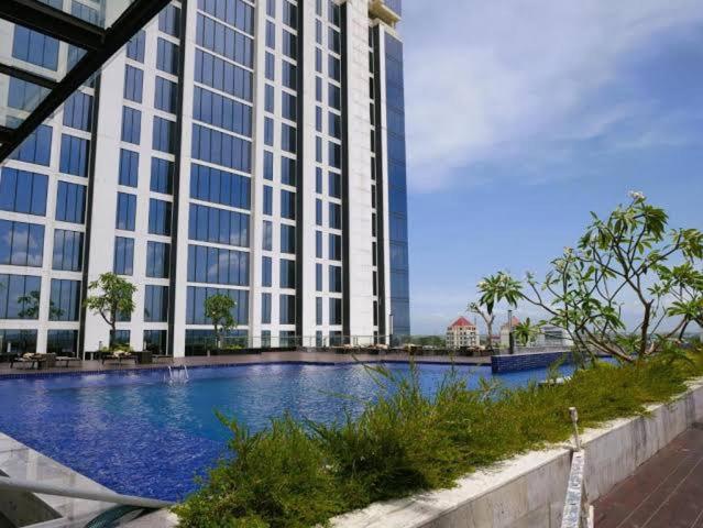 a large building with a swimming pool in front of it at Pollux Habibie batam in Batam Center