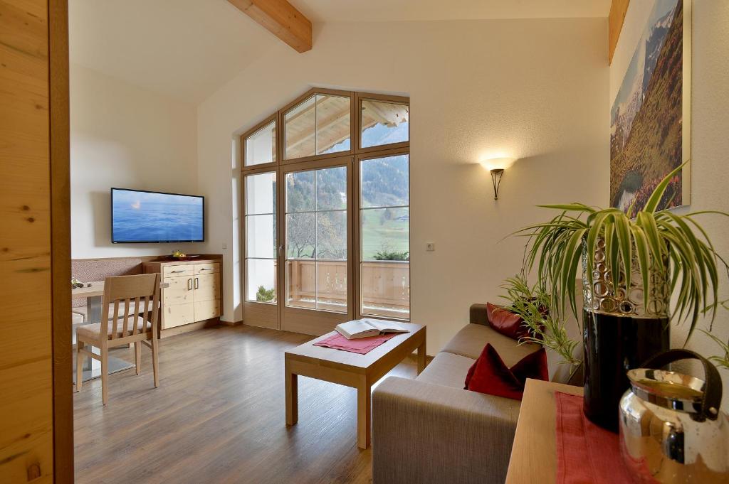ein Wohnzimmer mit einem Sofa und einem großen Fenster in der Unterkunft Ferienwohnung Sonnblick in Ramsau im Zillertal