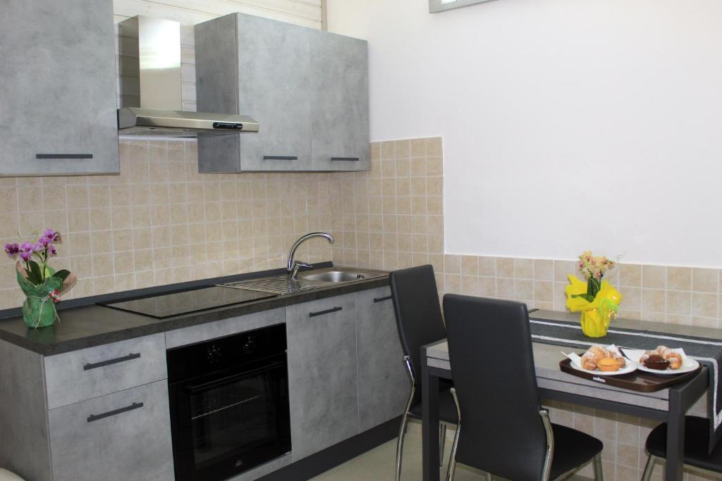 a kitchen with a sink and a table with a plate of food at Tenuta Paifer in Otranto