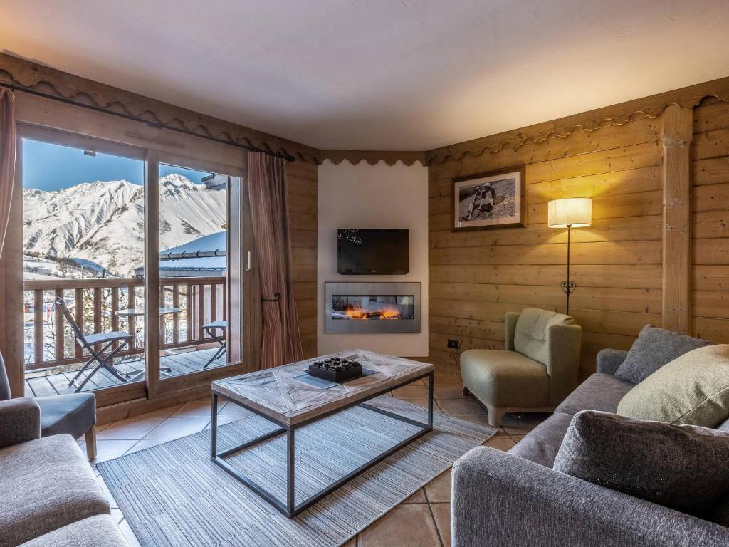 a living room with a couch and a table at Appartement cosy avec piscines et spa, pied de pistes, 8 pers, cheminée, parking, animaux admis - FR-1-461-19 in Saint-Martin-de-Belleville