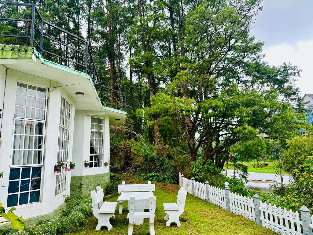 a white table and chairs in front of a house at Lakeside Cottage by Clover in Nuwara Eliya