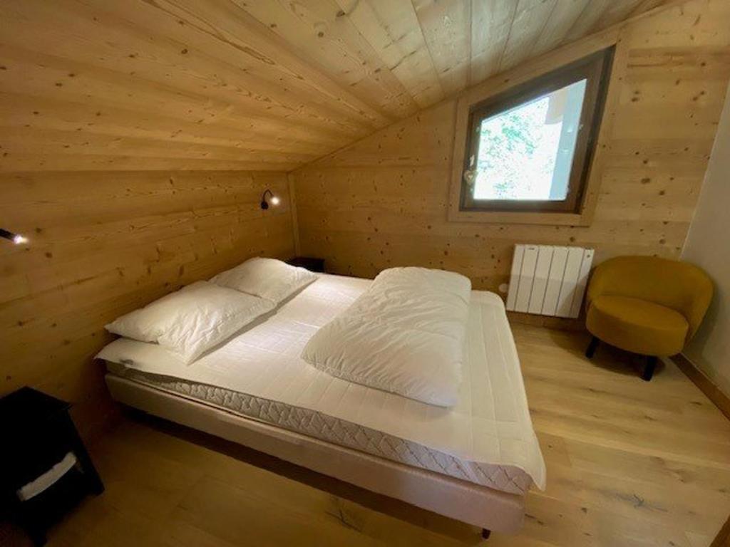 łóżko w drewnianym domku z oknem w obiekcie Appart rénové 2* pour 6 pers. avec 2 salles d'eau et balcon sud - FR-1-458-178 w mieście Le Chinaillon