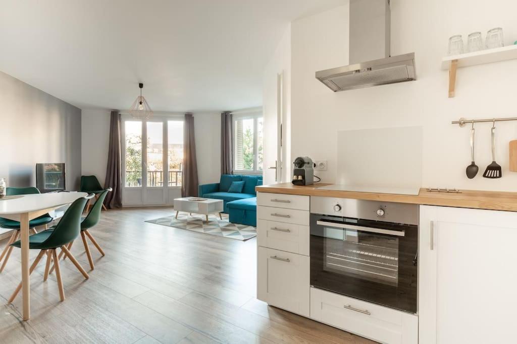 a kitchen and living room with a blue couch at L'aigle, Bel appartement Proche centre et parking in Grenoble