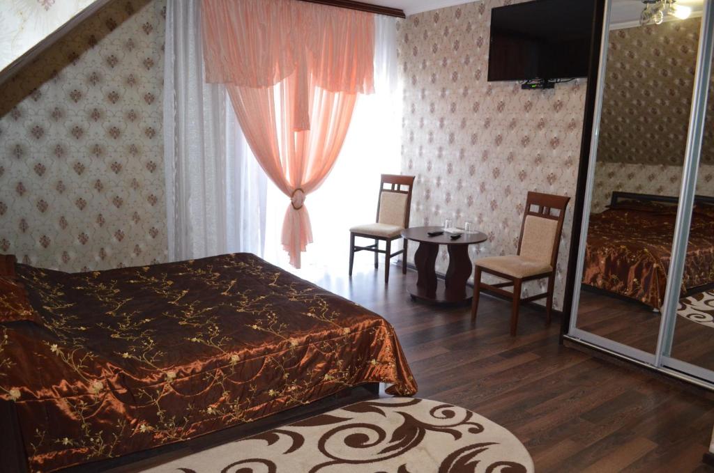 Starokostyantyniv的住宿－Hotel Fiyesta，一间卧室配有一张床、两把椅子和一个窗户