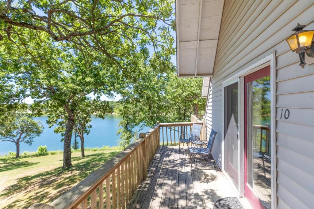 a house with a balcony with a view of the water at Artilla Cove Cabin 10- Lake views- Pool & Hot Tub in Branson