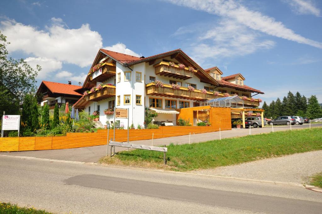 um grande edifício ao lado de uma estrada em Berghüs Schratt - EINFACH ANDERS - Ihr vegetarisches und veganes Biohotel em Oberstaufen