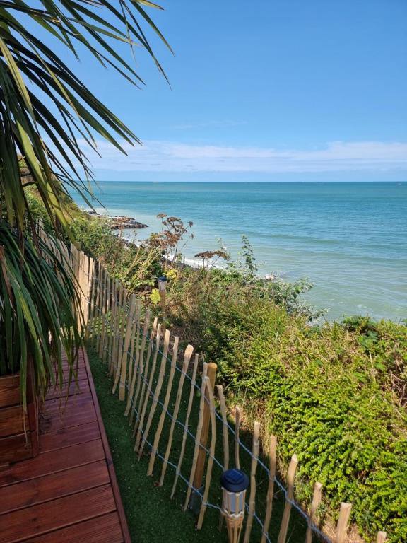a wooden pathway leading to a beach with the ocean at La Bayeuzen - La Mer in Saint-Côme-de-Fresné