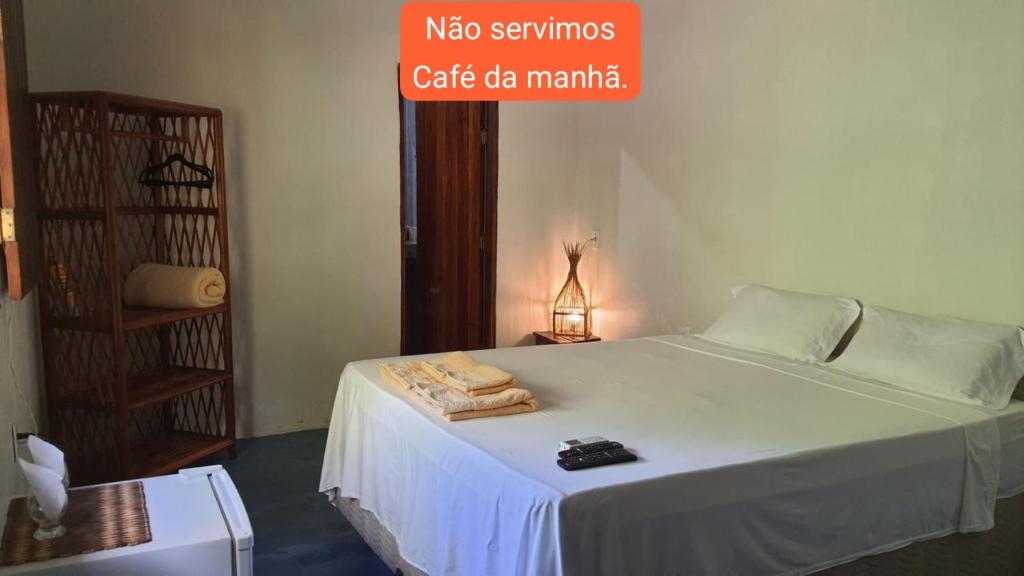 a bedroom with a white bed with towels on it at Casa Antiga Hospedagem - Taipu de Fora in Barra Grande