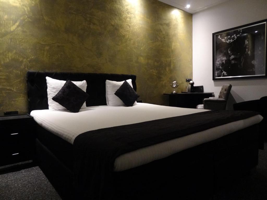 فندق ساراز البوتيكي في أمستردام: غرفة نوم بسرير كبير عليها شراشف ووسائد بيضاء