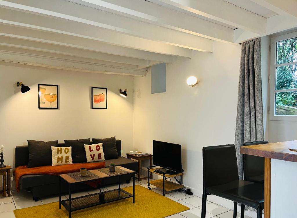 un salon avec un canapé et une table dans l'établissement Maison de ville rare vu château, à Caen