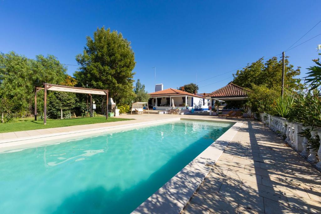 a swimming pool in front of a house at Alentejo Villa Nordic Spa & Pool in Santo António do Alcôrrego