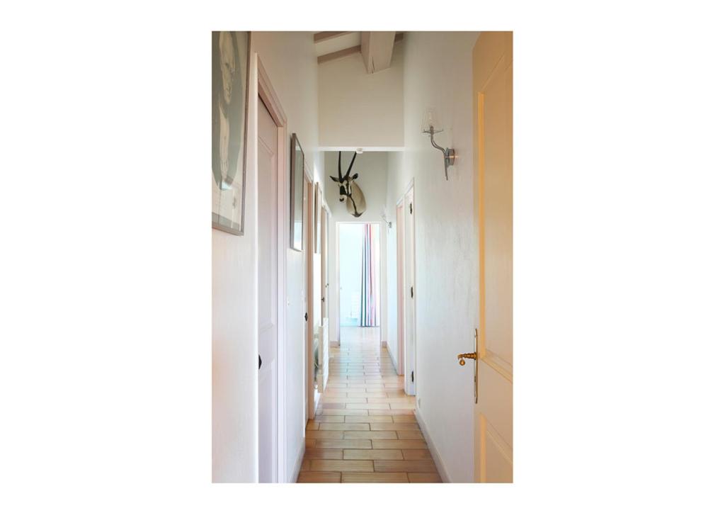 - un couloir avec des murs blancs et du carrelage dans l'établissement Nid d’aigle panorama Luberon, à Roussillon