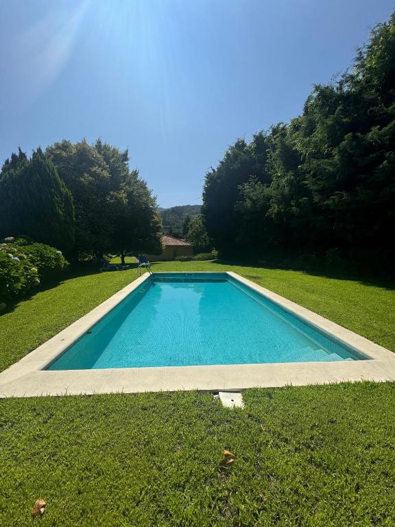 a swimming pool in the middle of a grass field at Quinta da Ponte in Resende