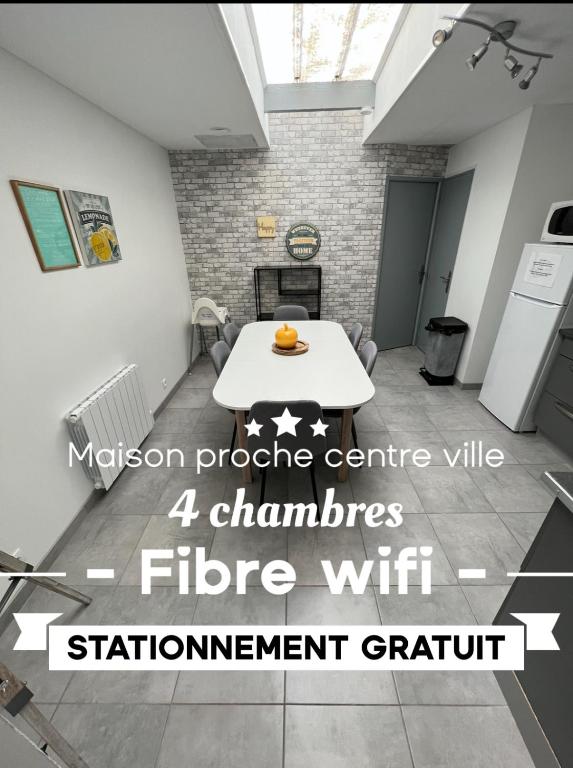 Cette chambre comprend une table et une table blanche. dans l'établissement L'amiénoise proche zenith stade cathédrale, à Amiens